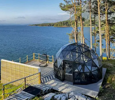 a glass house on a dock by the water at A little corner of paradise in Molde