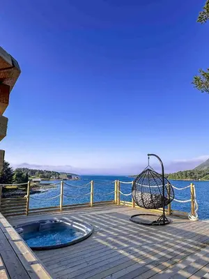 a hot tub on a deck next to the water at A little corner of paradise in Molde