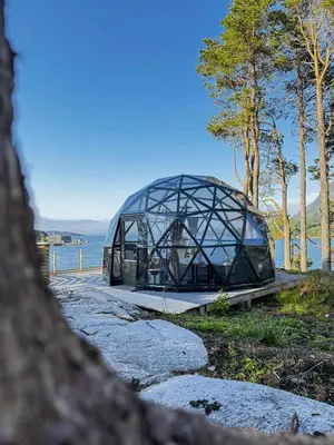 a glass building on the side of a body of water at A little corner of paradise in Molde