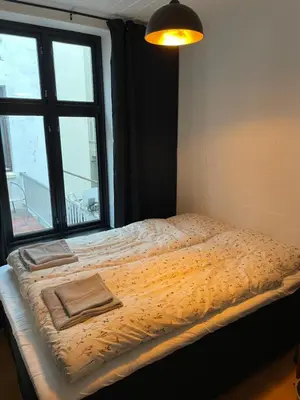 a bed in a room with a large window at Ålesund Central Apartment in Ålesund