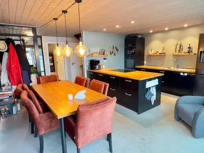 a kitchen with a wooden table and some chairs at 6 person holiday home in Huglo in Nordhuglo