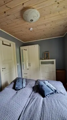 a bedroom with a bed with blue pillows and a ceiling at Seaside cabin with stunning view! in Ålesund