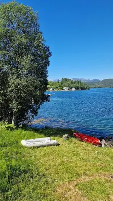 two boats on the grass next to a lake at Seaside cabin with stunning view! in Ålesund