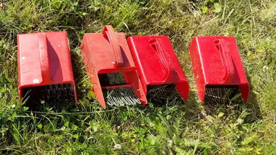 three red plastic chairs sitting in the grass at Seaside cabin with stunning view! in Ålesund