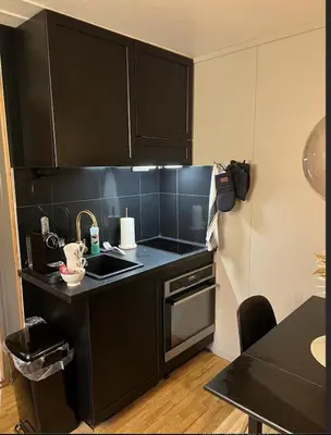 a kitchen with black cabinets and a sink at Hafjell Alpinlandsby in Hafjell