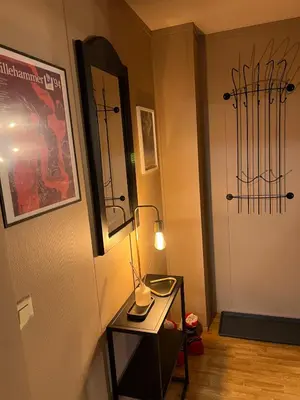 a room with a table with a lamp and a door at Hafjell Alpinlandsby in Hafjell