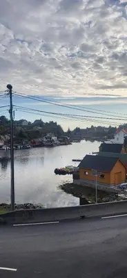 a view of a river with a building and a house at Cottage in Hellesøy, Øygarden in Hellesøy
