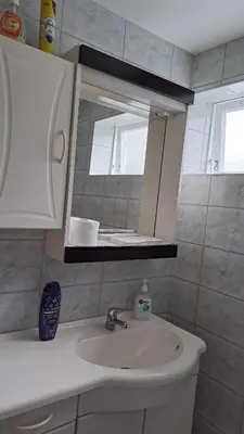 a bathroom with a sink and a mirror at Garsoniera in Leirvåg