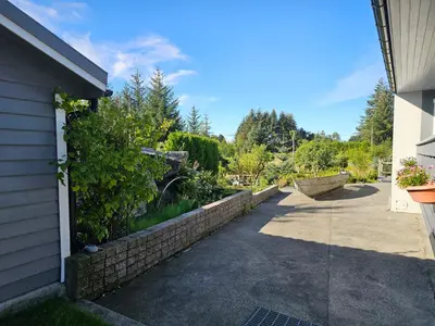 a brick retaining wall next to a driveway at Garsoniera in Leirvåg