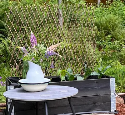a vase sitting on a table in a garden at WOOD HOUSE GARDEN Lakeview Mjøsa -30 min OSL