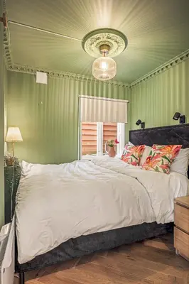 a bedroom with a large bed with a green wall at Bispengsgaten 16 in Bergen