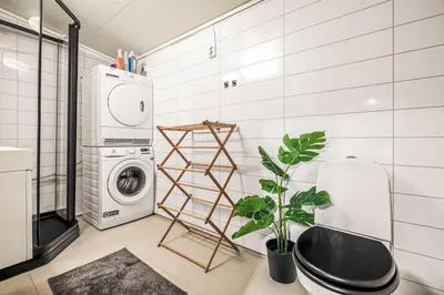 a bathroom with a washing machine and a plant at Bispengsgaten 16 in Bergen