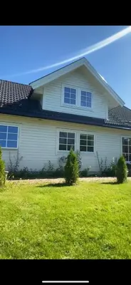 a white house with windows on a lawn at Helt hus leies ut under fiskeri messe 2025 in Trondheim