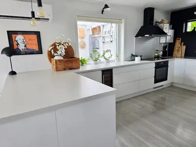 a white kitchen with white cabinets and a window at Sentrumsidyll ved fjord og fjell in Molde