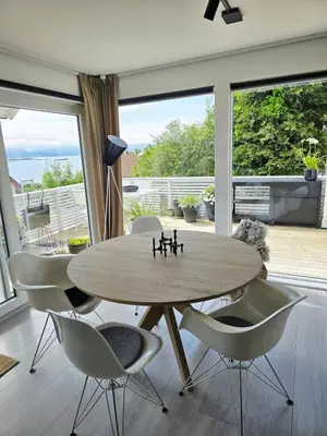 a dining room with a wooden table and chairs at Sentrumsidyll ved fjord og fjell in Molde