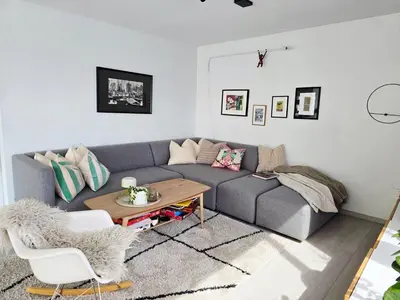 a living room with a gray couch and a table at Sentrumsidyll ved fjord og fjell in Molde
