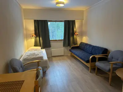 a room with a couch and a bed and a window at Bjorliheimen Fjellhotell-Hotellrom in Bjorli
