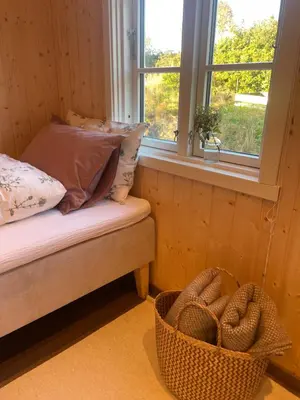 a bedroom with a bed and a window and a basket at Cozy older house in scenic surroundings in Stord