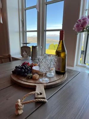 a bottle of wine and wine glasses on a table at Cozy older house in scenic surroundings in Stord