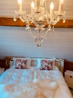 a bedroom with a chandelier and a bed at Cozy older house in scenic surroundings in Stord