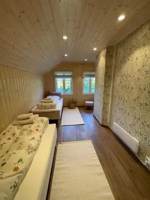 a room with three beds and a wall with wallpaper at Cozy older house in scenic surroundings in Stord