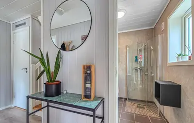 a bathroom with a shower and a table with a mirror at Amazing Home In Bremnes With Wifi in Bremnes
