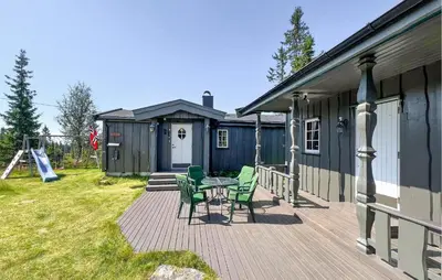 a deck with chairs and a table in front of a house at Beautiful Home In Sjusjøen With Sauna in Sjusjøen