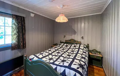 a bedroom with a bed and a chandelier at Beautiful Home In Sjusjøen With Sauna in Sjusjøen