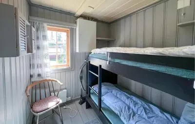 a room with two bunk beds and a chair at Beautiful Home In Sjusjøen With Sauna in Sjusjøen