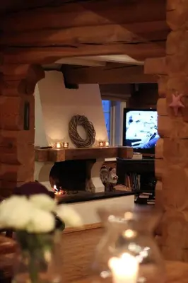 a living room with a fireplace and a table at Stor velutstyrt laftehytte med usjenert uteplass, flott utsikt og Jacuzzi in Eggedal