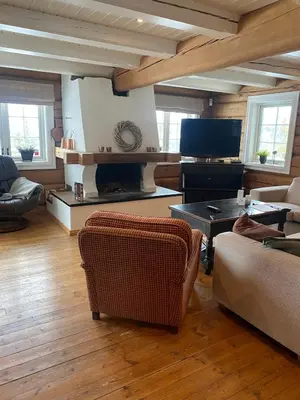 a living room with a couch and a table at Stor velutstyrt laftehytte med usjenert uteplass, flott utsikt og Jacuzzi in Eggedal