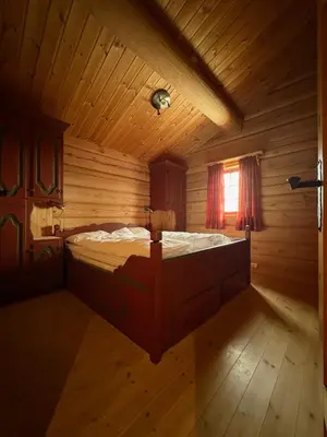 a bedroom with a bed in a wooden room at Lomtjern in Beitostøl