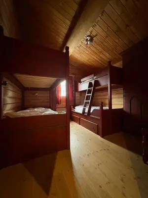 an attic room with two bunk beds and a ladder at Lomtjern in Beitostøl