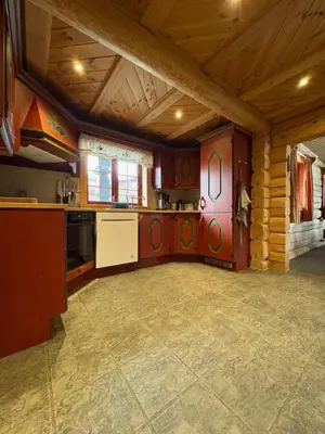 a large kitchen with wooden ceilings and a large room at Lomtjern in Beitostøl