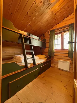 a room with two bunk beds in a cabin at Lomtjern in Beitostøl