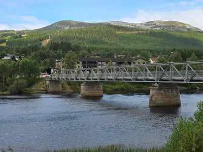 a bridge over a river with a train on it at 6 person holiday home in Osen