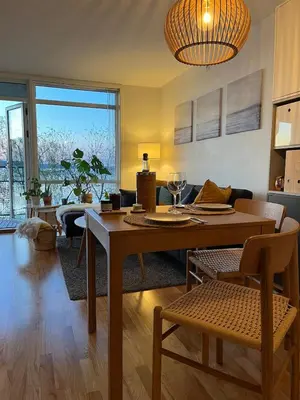 a living room with a wooden table and a dining room at Exclusive flat with amazing view over the fjord in Trondheim