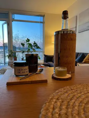 a wooden table with a bottle and a candle on it at Exclusive flat with amazing view over the fjord in Trondheim