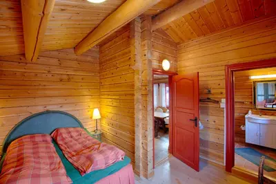 a bedroom with a bed in a wooden room at Stor tømmerhytte med fjellutsikt in Beitostøl