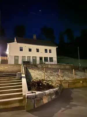 a large white house with animals in front of it at Haraldseidvågen gjestgjevarstad in Skjold