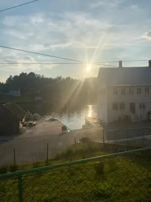 a view of a house and a body of water at Haraldseidvågen gjestgjevarstad in Skjold