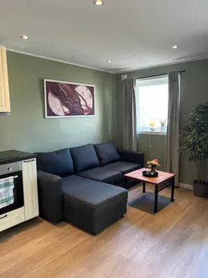a living room with a blue couch and a table at Mai Tran in Gjøvik