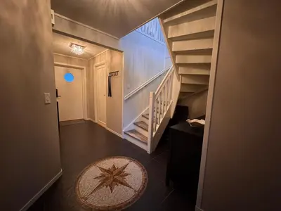 a hallway with a staircase and a star rug at Modern apartment, large terrace free parking and Wallbox in Ytterland