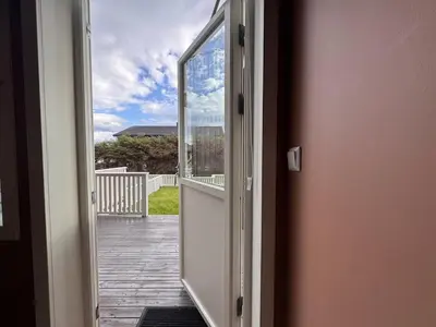 an open door with a view of a porch at Modern apartment, large terrace free parking and Wallbox in Ytterland