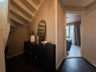 a bedroom with a bed and a dresser with a mirror at Modern apartment, large terrace free parking and Wallbox in Ytterland