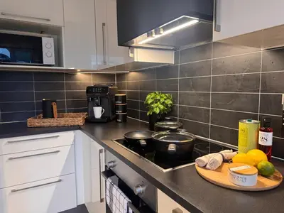a kitchen with a wooden cutting board on a counter at Modern apartment, large terrace free parking and Wallbox in Ytterland