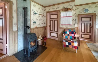 a living room with a wood stove and a chair at Stunning Home In Engerdal With Wifi in Nymoen