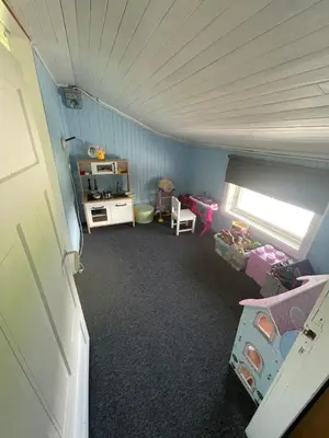 an attic room with a room with a kitchen and a bedroom at Flott feriehus ved sjøen