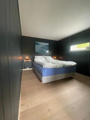 a bedroom with a bed in a black wall at Flott feriehus ved sjøen