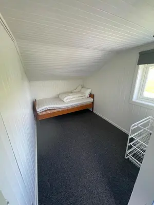 a small room with a bed and a window at Flott feriehus ved sjøen